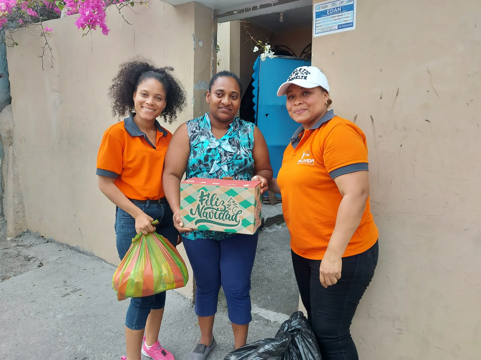 Voluntarias de Fluvida entregan una canasta navideña a una vecina de Melida Toral
